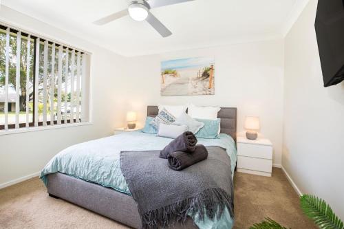 a bedroom with a bed and a window at Wildwood I Pet Friendly I 5 Mins to Beach in Callala Beach