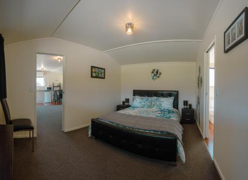 a bedroom with a bed with blue pillows at Te Awa Cottages in Franz Josef