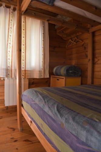 a bedroom with a bed in a wooden cabin at El Llano de los Conejos Serranía de Cuenca in Cañamares