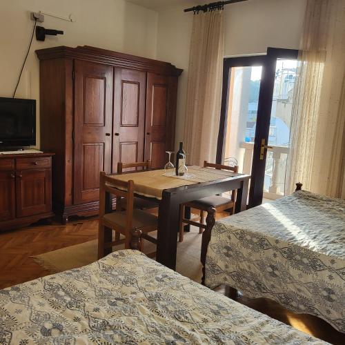 a room with a dining room table and a tv at Studio apartman in Meljine