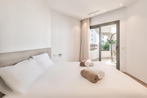 a bedroom with a white bed with towels on it at Jardines - Tabor 2 1 POOL VIEW 2B in Palm-Mar