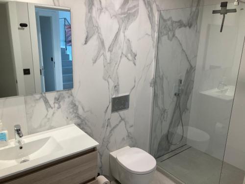 a bathroom with a sink and a toilet and a shower at Casa Flamencos in Rojales