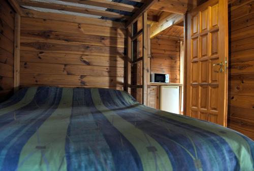a bedroom with a bed in a log cabin at El Llano de los Conejos Serranía de Cuenca in Cañamares