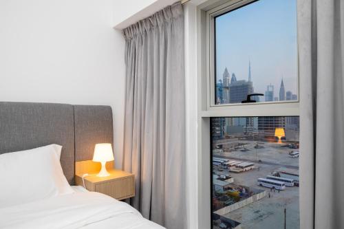 a bedroom with a window with a view of a city at ALH Vacay - Modern 2 Bedroom suitable for family in Dubai