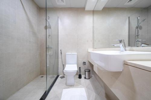 a bathroom with a toilet and a sink and a shower at ALH Vacay - Modern 2 Bedroom suitable for family in Dubai