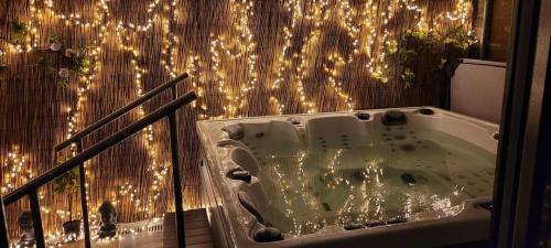 eine Badewanne auf einem Balkon mit Beleuchtung in der Unterkunft Le cocon de sofalia in Courcelles