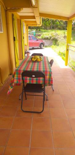 a table with a plaid table cloth on a patio at Appartement confortable avec vue sur le jardin - Le Robert in Le Robert