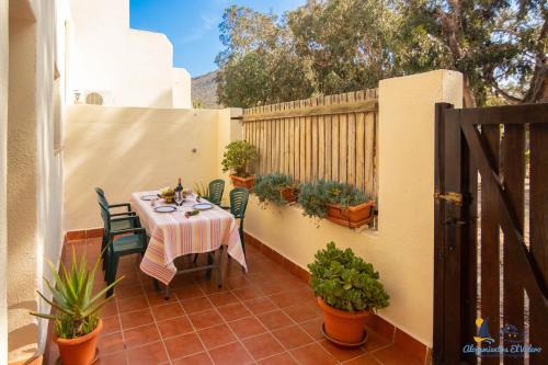 a patio with a table and chairs and a fence at El Velero Sotillo Piscina Wifi Playa in San José