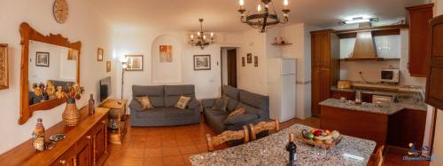 sala de estar amplia con sofá y cocina en El Velero Sotillo con Piscina, en San José