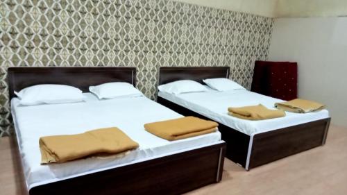 two beds sitting next to each other in a room at Shree Yatri Niwas in Kolhapur