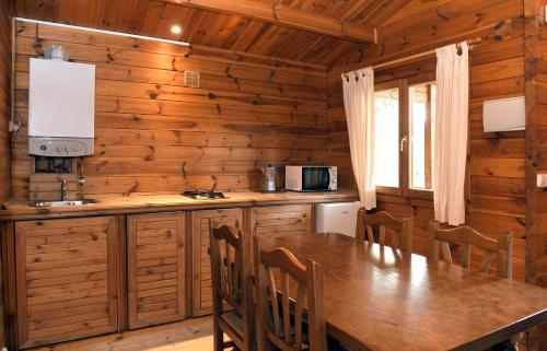 a kitchen with a long wooden table and chairs at El Llano de los Conejos Serranía de Cuenca in Cañamares