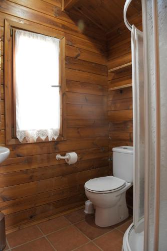 a wooden bathroom with a toilet and a window at El Llano de los Conejos Serranía de Cuenca in Cañamares