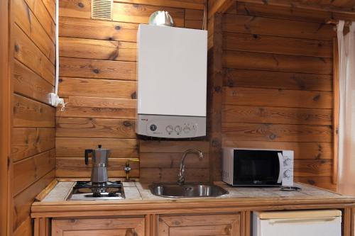 a kitchen with a sink and a microwave at El Llano de los Conejos Serranía de Cuenca in Cañamares