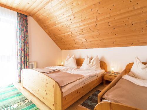 a bedroom with two beds and a wooden ceiling at Beautiful Holiday Home in Weinebene with Sauna in Posch Alpe