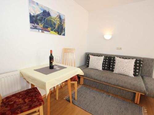 salon z kanapą i stołem z butelką wina w obiekcie Apartment in Huben near Ski Slopes w Langenfeld