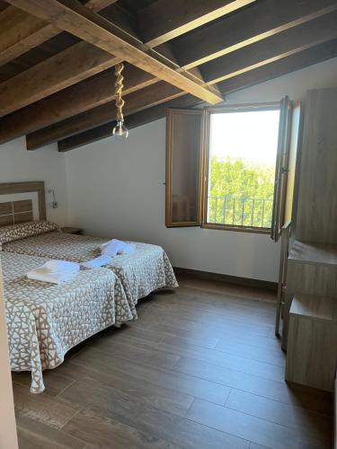 1 dormitorio con cama y ventana grande en PENSION ORUEIRO VILASERIO, en Negreira