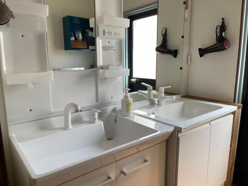 - une salle de bains blanche avec deux lavabos et un miroir dans l'établissement Guest house Nagi - Vacation STAY 21489v, à Kanayama