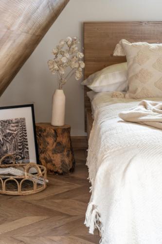 a bedroom with a bed and a vase with flowers at Jedla Apartments in Dzianisz