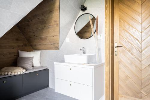 a bathroom with a sink and a mirror at Jedla Apartments in Dzianisz