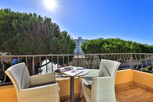 a balcony with a table and chairs on a balcony at Le Petit Prince in Sainte-Maxime