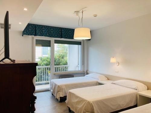 a bedroom with two beds and a window at Hotel Ghironi in La Spezia