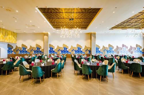 a banquet hall with tables and chairs and a large wall at Muong Thanh Luxury Ha Long Residence in Ha Long