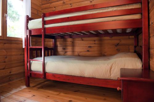 a bedroom with two bunk beds in a log cabin at El Llano de los Conejos Serranía de Cuenca in Cañamares