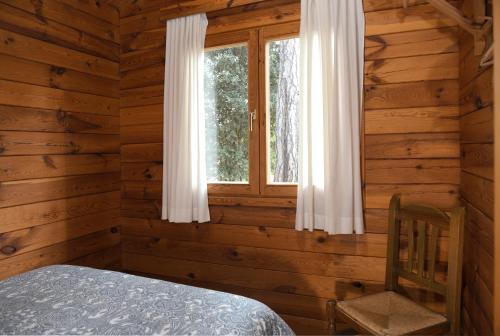 a bedroom with a window in a log cabin at El Llano de los Conejos Serranía de Cuenca in Cañamares
