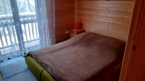 een klein bed in een kamer met een raam bij Domek Pod Smrekiem in Marcinkowice