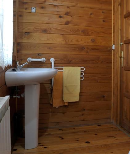 a bathroom with a sink and a wooden wall at El Llano de los Conejos Serranía de Cuenca in Cañamares