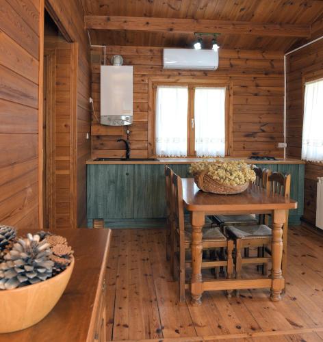 a kitchen with wooden walls and a wooden table and chairs at El Llano de los Conejos Serranía de Cuenca in Cañamares
