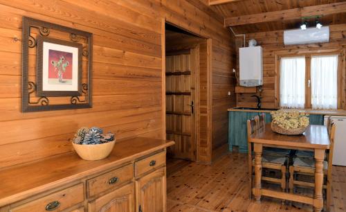 a kitchen with wooden walls and a wooden table in a cabin at El Llano de los Conejos Serranía de Cuenca in Cañamares