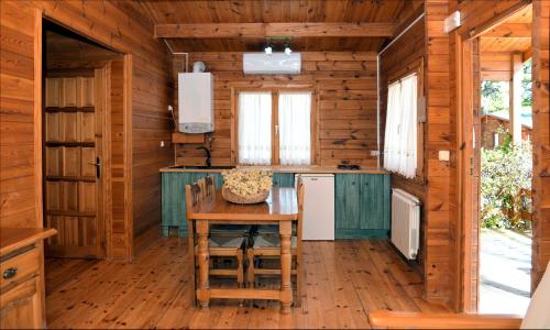 a kitchen in a log cabin with a table and chairs at El Llano de los Conejos Serranía de Cuenca in Cañamares