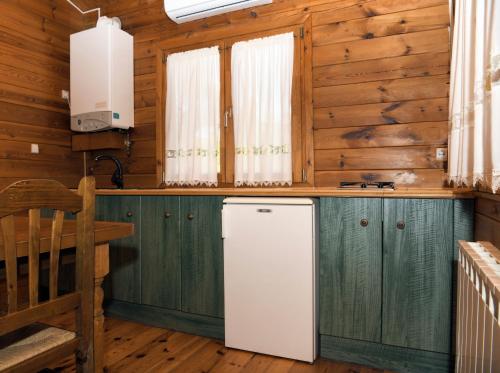 a kitchen with a refrigerator and a table in a cabin at El Llano de los Conejos Serranía de Cuenca in Cañamares