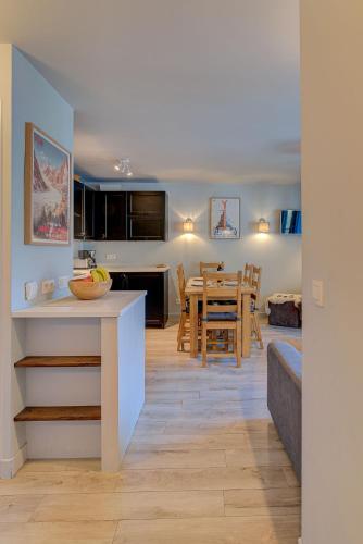 une cuisine et un salon avec une table et des chaises dans l'établissement Apartment Fermes du Montenvers B2- Alpes Travel - Central Chamonix (sleeps 4-5), à Chamonix-Mont-Blanc