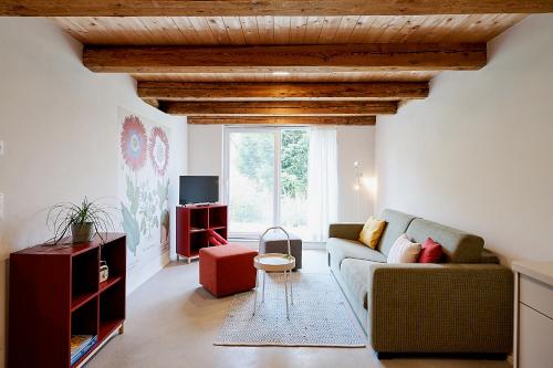 a living room with a couch and a window at Gutshof Schirgiswalde in Schirgiswalde
