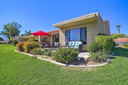 a house with a patio with chairs and an umbrella at Golf Course View and Pool Access Palm Desert Home in Palm Desert