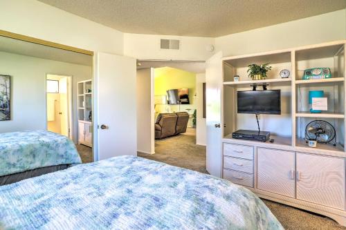 a bedroom with a bed and a flat screen tv at Golf Course View and Pool Access Palm Desert Home in Palm Desert