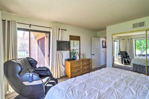 a bedroom with a bed and a chair and a television at Golf Course View and Pool Access Palm Desert Home in Palm Desert