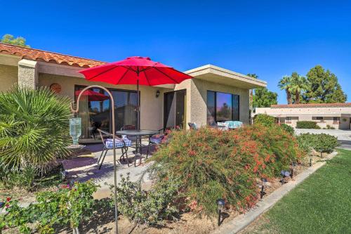 a red umbrella in front of a house at Golf Course View and Pool Access Palm Desert Home in Palm Desert