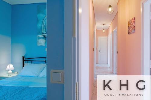um quarto com uma cama azul e um corredor em Villa Aliki with Infinity Pool at Kaminarata Village em Kaminaráta