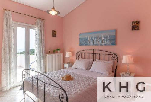 a bedroom with a bed with pink walls and a window at Villa Aliki with Infinity Pool at Kaminarata Village in Kaminaráta