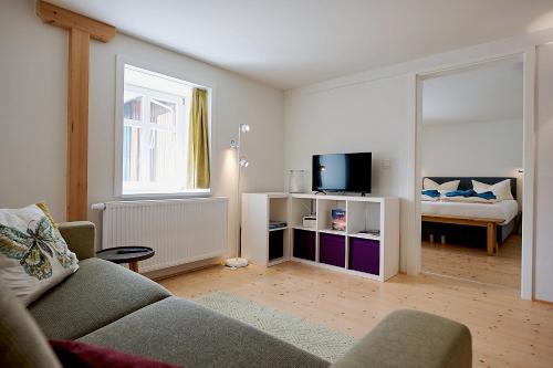 a living room with a couch and a television at Gutshof Schirgiswalde in Schirgiswalde