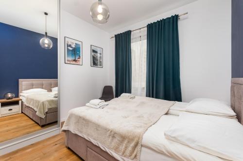1 dormitorio con 2 camas y espejo en Jurajska 4 by Homeprime, en Varsovia