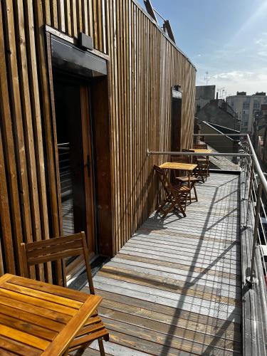 a wooden deck with tables and benches on a building at 9WAGRAM Hotel Boutique in Le Mans
