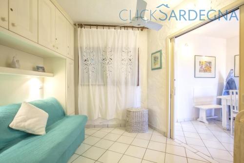 uma sala de estar com um sofá azul e uma janela em Costa Corallina Villa con spiaggia sotto casa e vista meravigliosa em Costa Corallina
