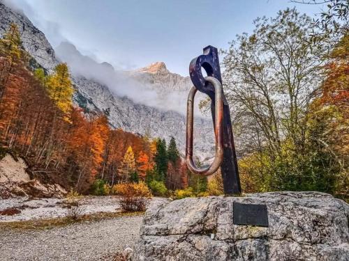 a sculpture on a rock in front of a mountain at Apartments Blažič in Kranjska Gora