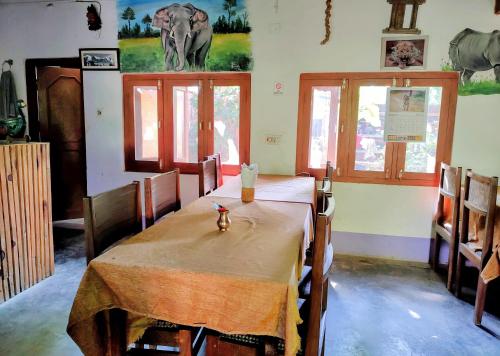 ein Esszimmer mit einem Tisch und einem Elefanten an der Wand in der Unterkunft Jungle Heaven Hotel and Cottage in Bhurkīā