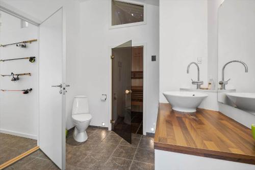 a white bathroom with a sink and a toilet at Lækkert kvalitetshus tæt på vandet in Nibe
