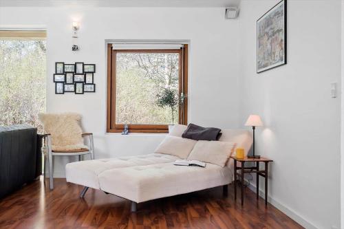ein Wohnzimmer mit einem weißen Sofa und einem Fenster in der Unterkunft Lækkert kvalitetshus tæt på vandet in Nibe